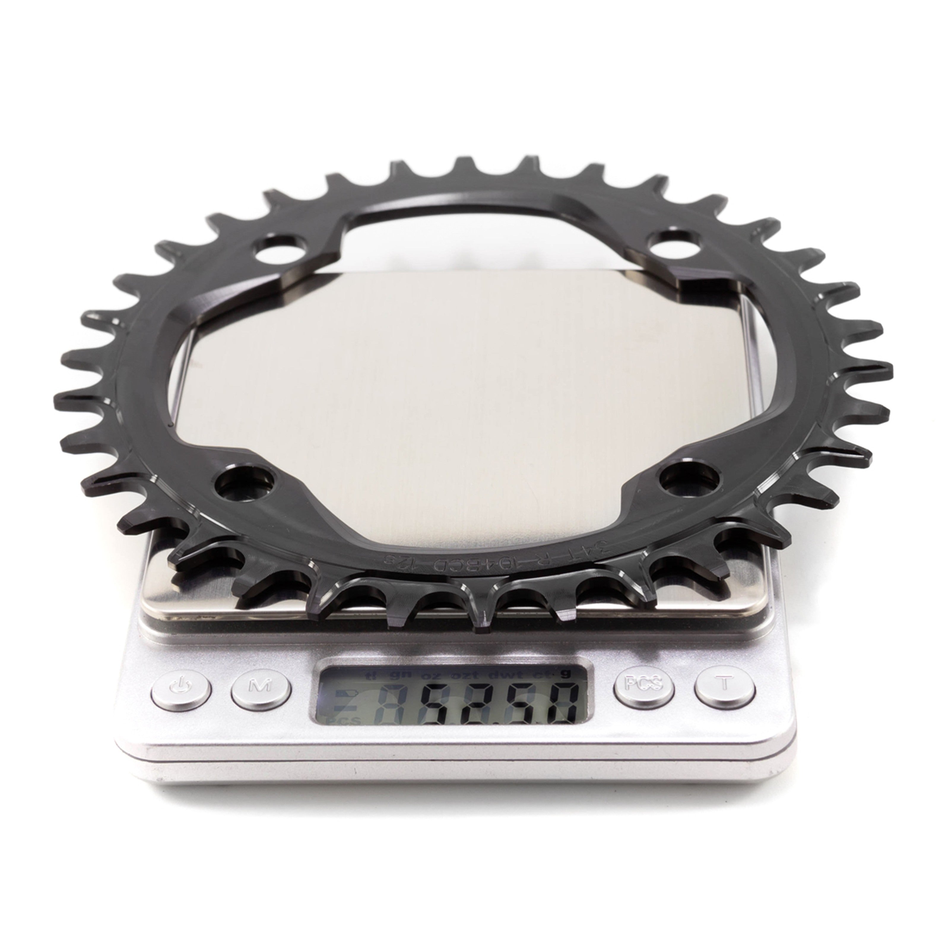 Garbaruk 104 BCD black chainring on a digital scale, which is displaying 52.5g