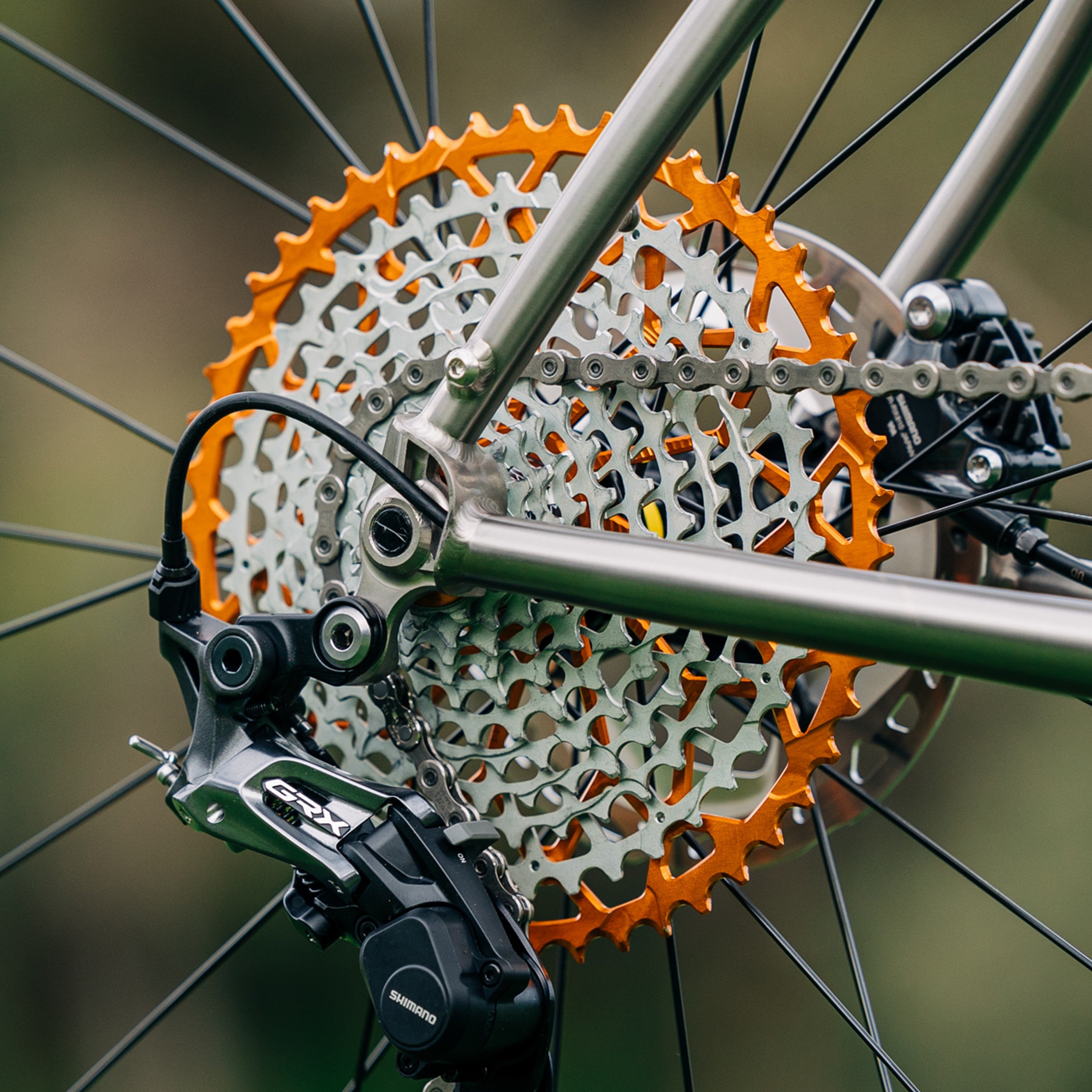 Orange Garbaruk 11-speed Shimano-compatible cassette mounted on a titanium Bossi bike, photographed outdoors
