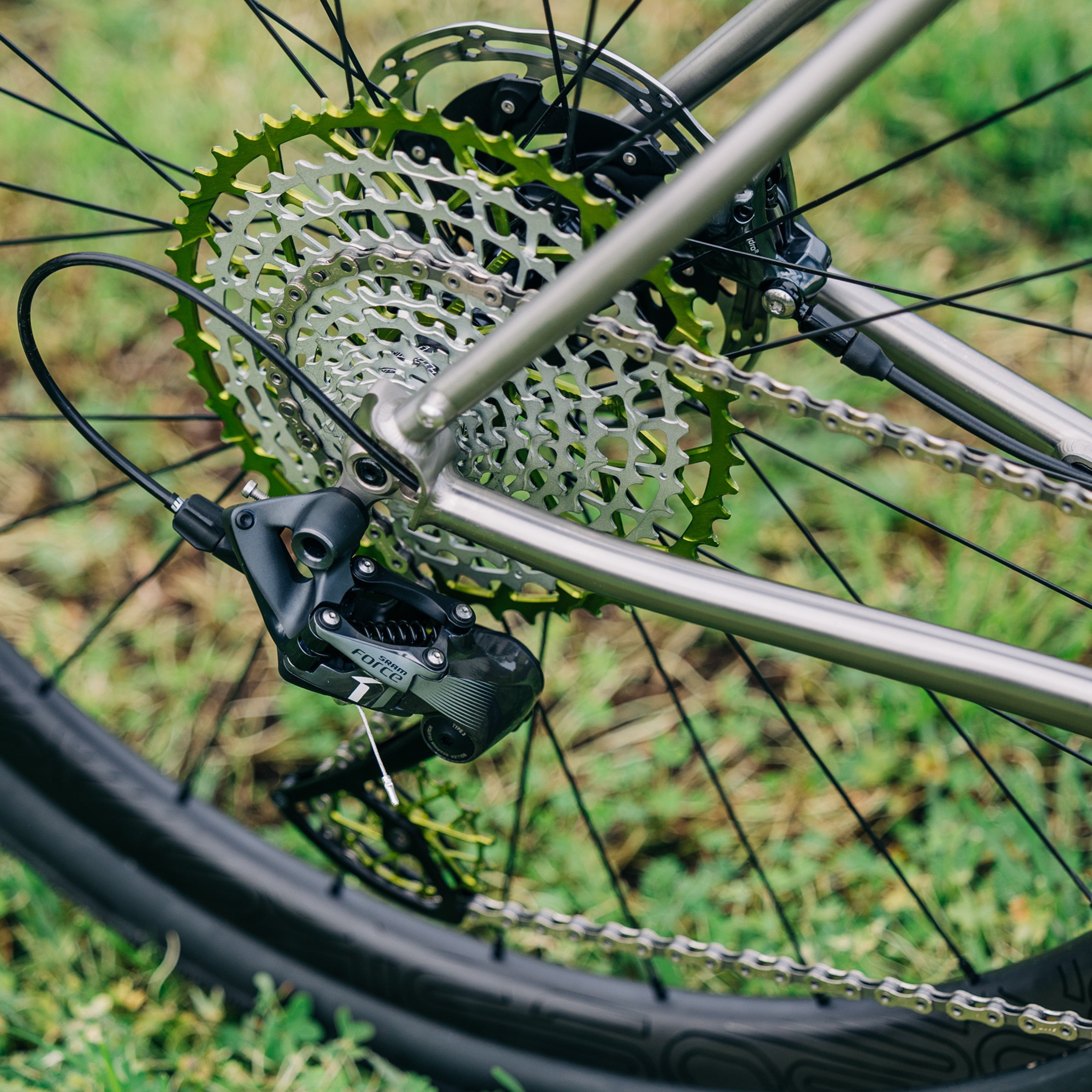Garbaruk 11-speed SRAM XD freehub cassette in green mounted on a Bossi bike, photographed outdoors against green lawn