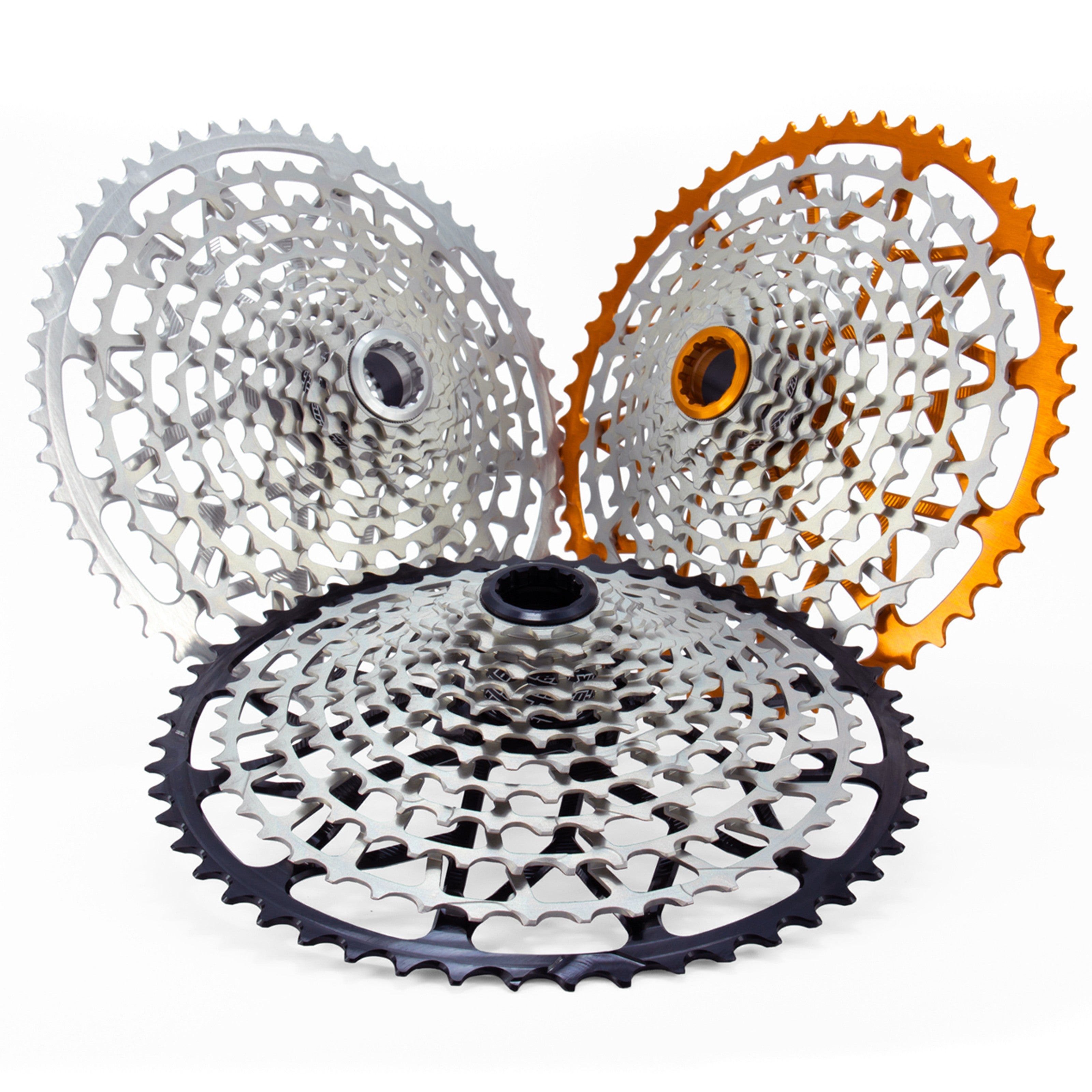Three Garbaruk 12sp Shimano Microspline cassettes (black, silver and orange), highlighting the CNC-machined monoblock construction and unique tooth profiling