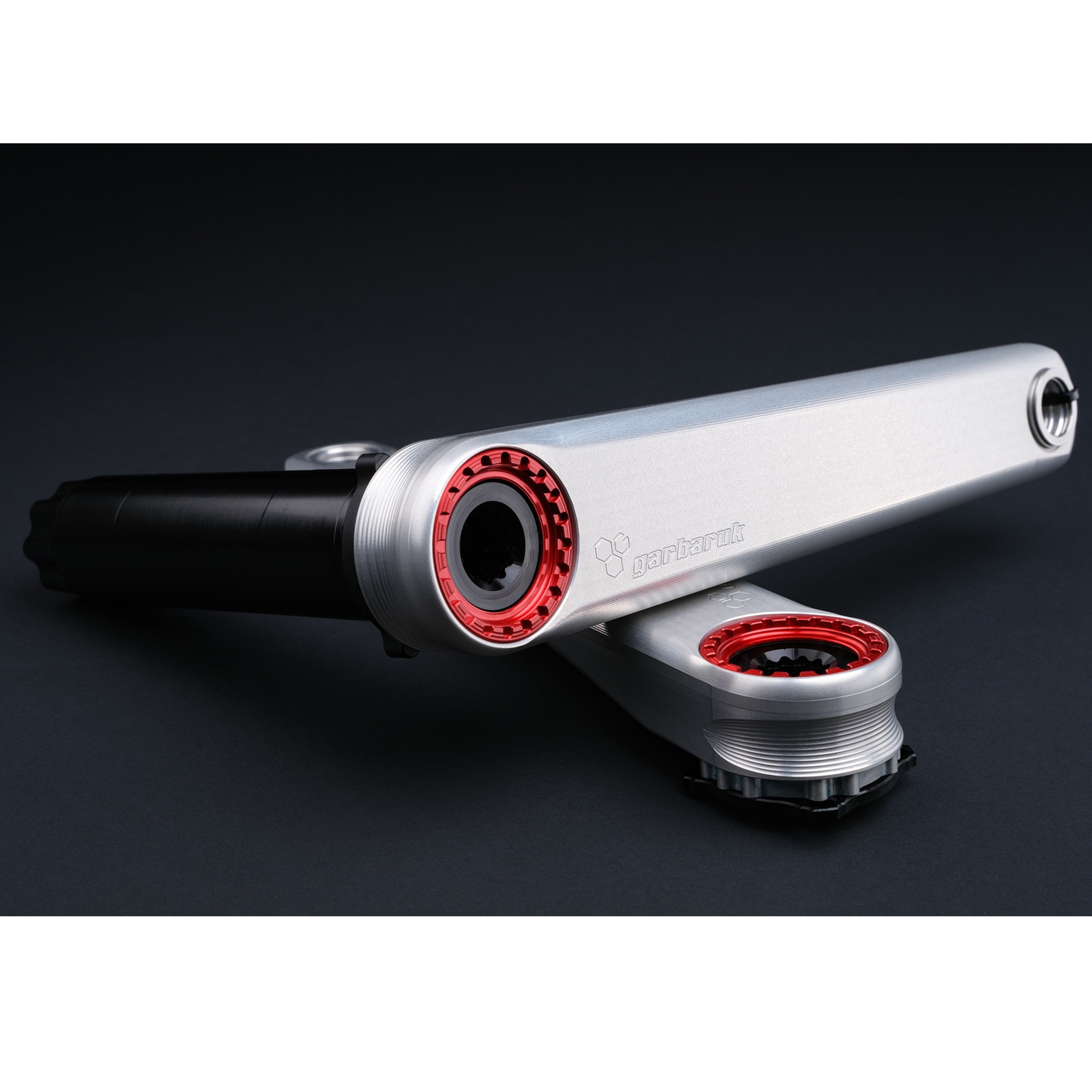 Detail of Garbaruk XC silver crank arms with red extractors, highlighting laser-etched logo and machining quality