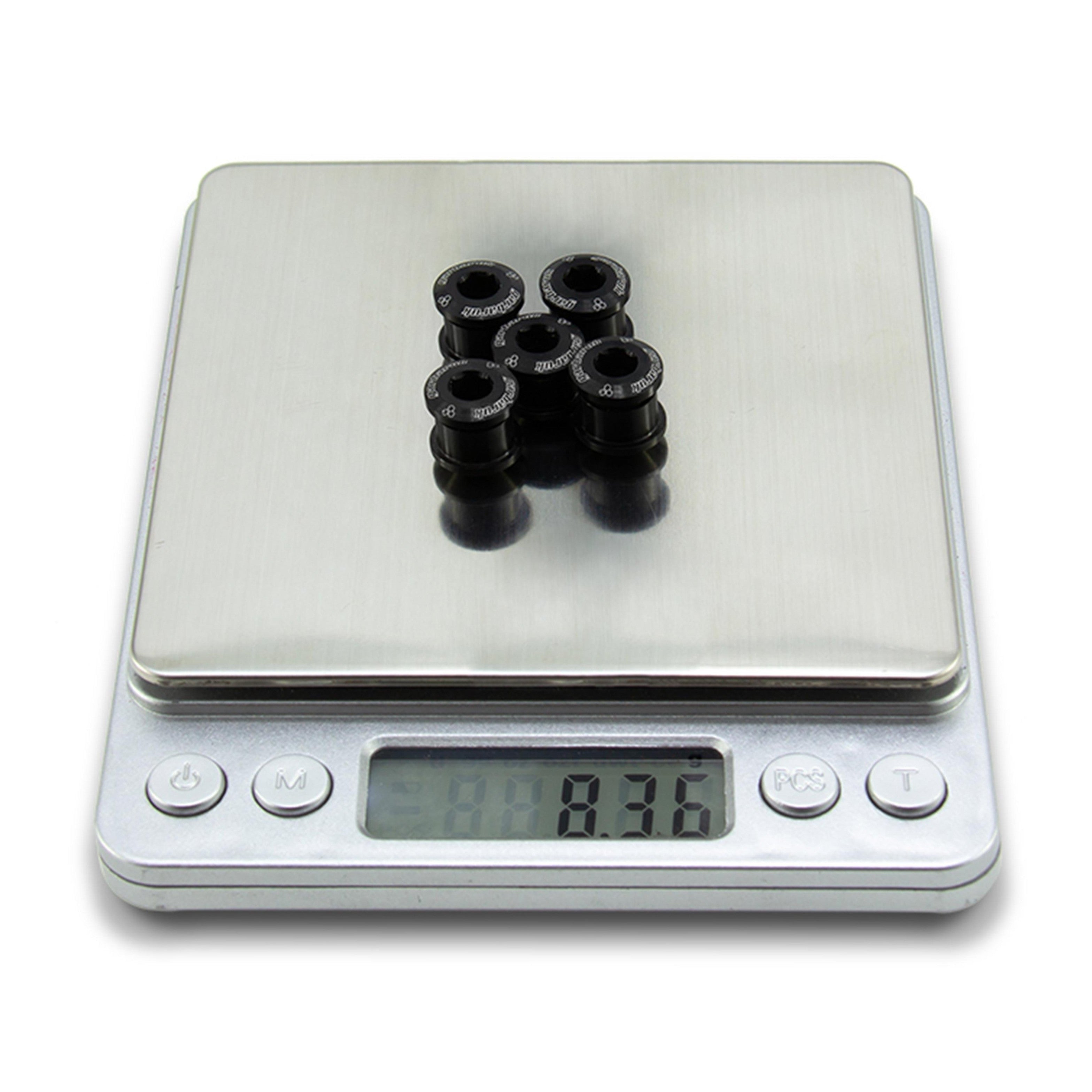 Set of black Garbaruk M8 x 0.75 chainring bolts on scale, demonstrating total weight (8.36g)