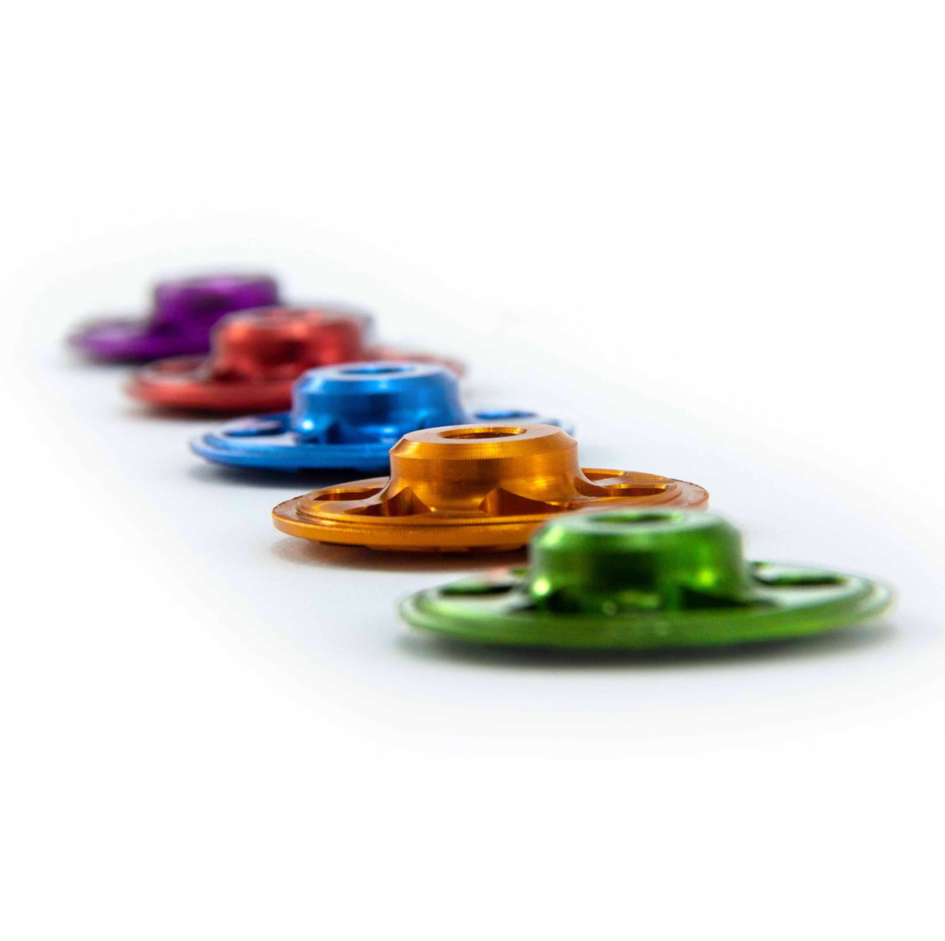 Angled side view of Garbaruk top caps in a range of colours, highlighting anodised finish and CNC-machined detailing