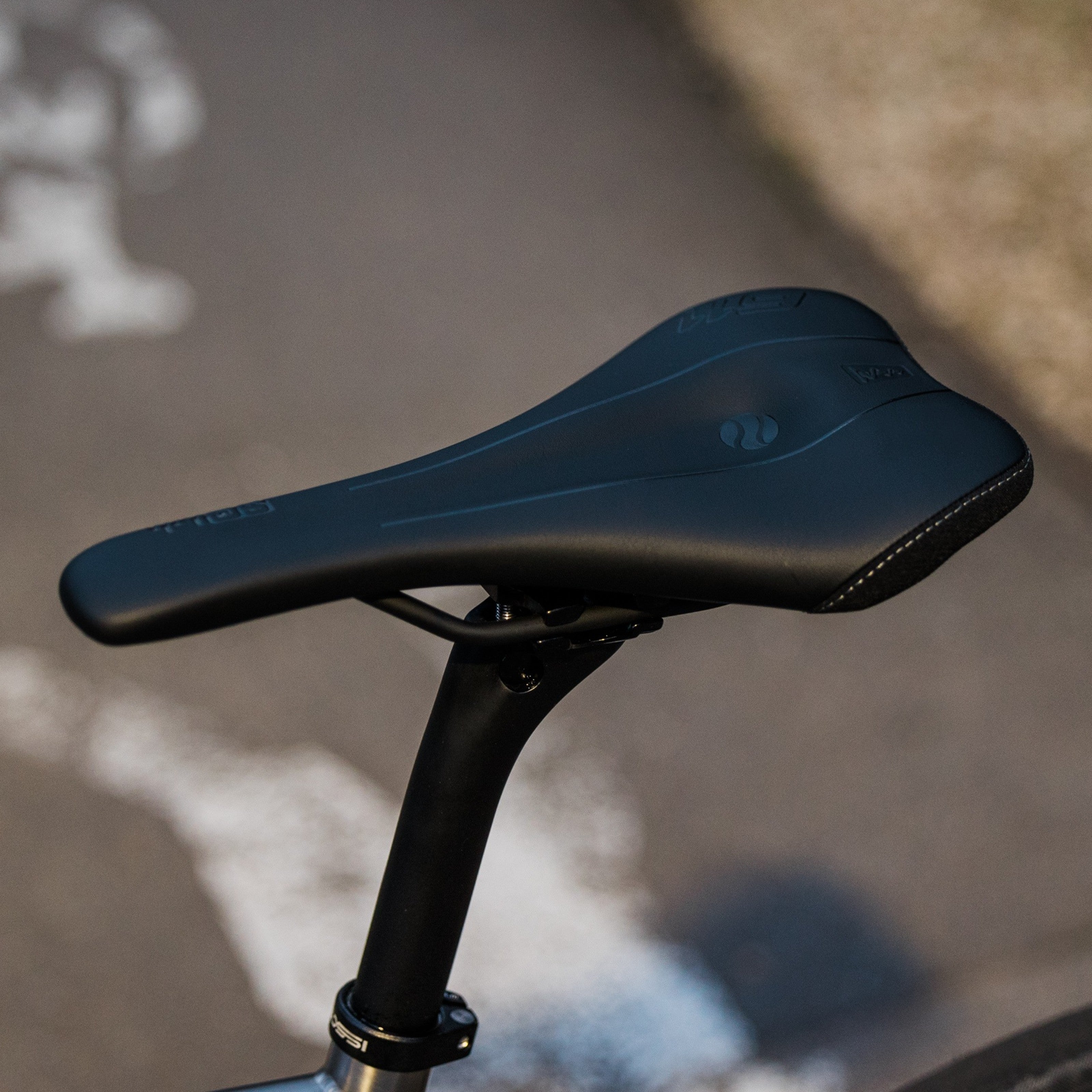 SQLab 611 Ergowave saddle installed on a custom Bossi gravel bike, photographed outdoors with natural background