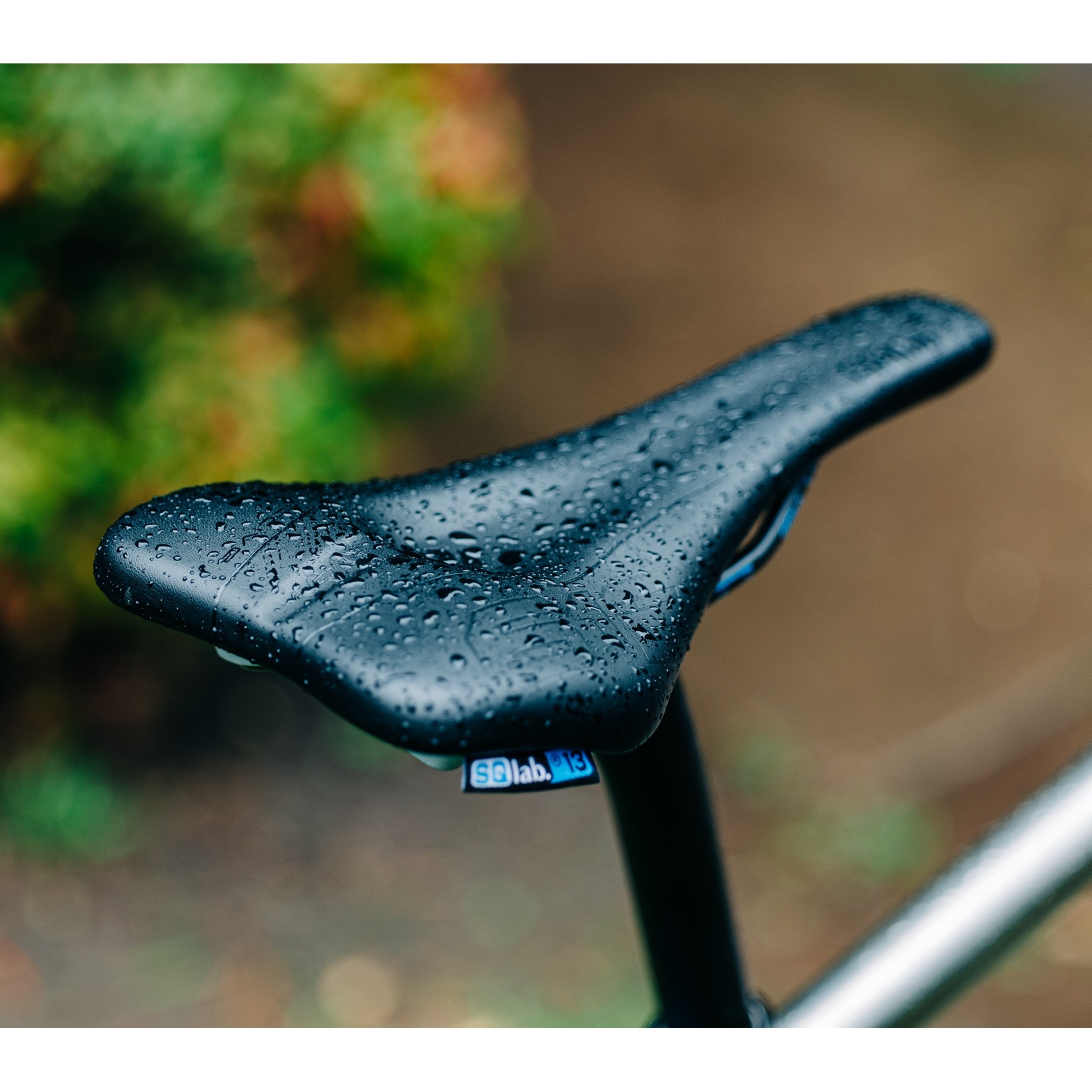 SQLab 612 Ergowave Active 2.1 saddle installed on a titanium Bossi road bike, photographed in a garden on a rainy day