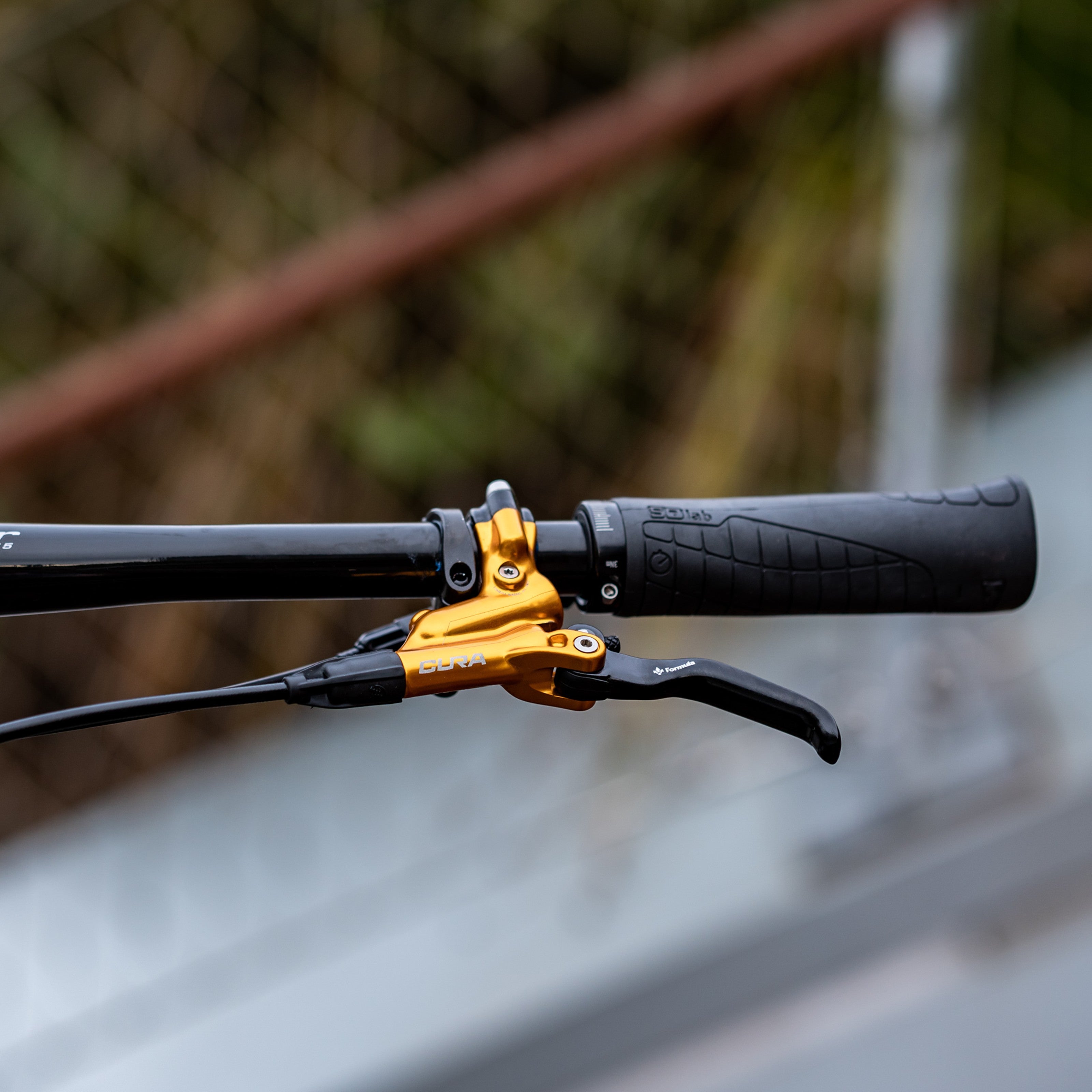 SQLab 711 grip installed on a flat bar mountain bike, photographed outdoors in front of a chainlin fence