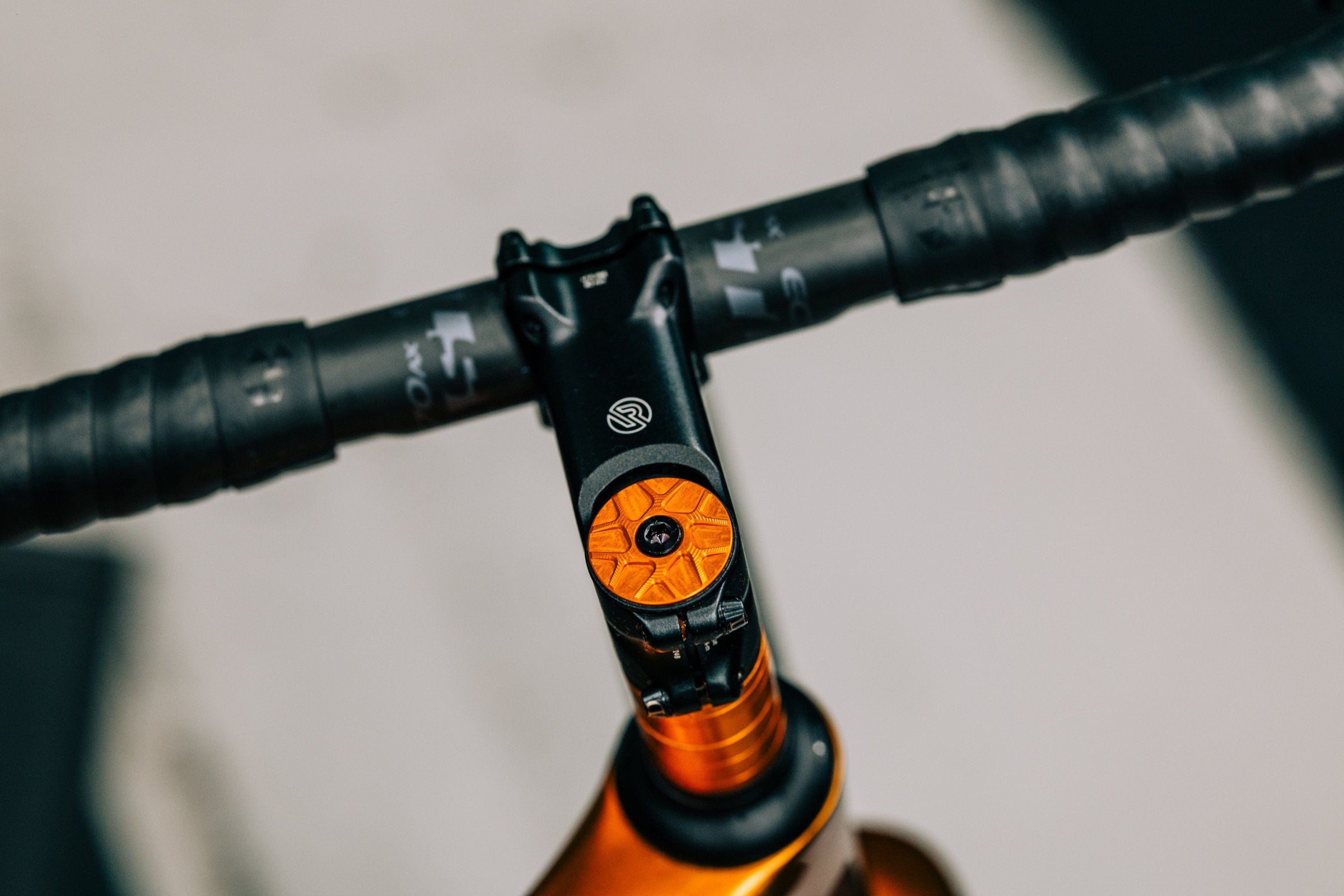 Garbaruk top cap in orange, fitted to a carbon gravel bike