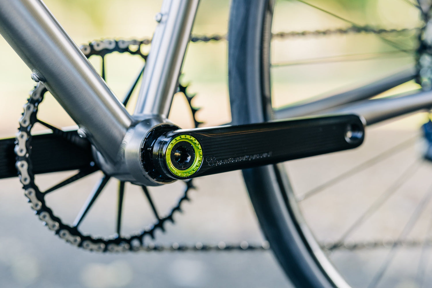 A black Garbaruk Road/Gravel crankset fitted to a titanium Bossi bicycle, photographed outside