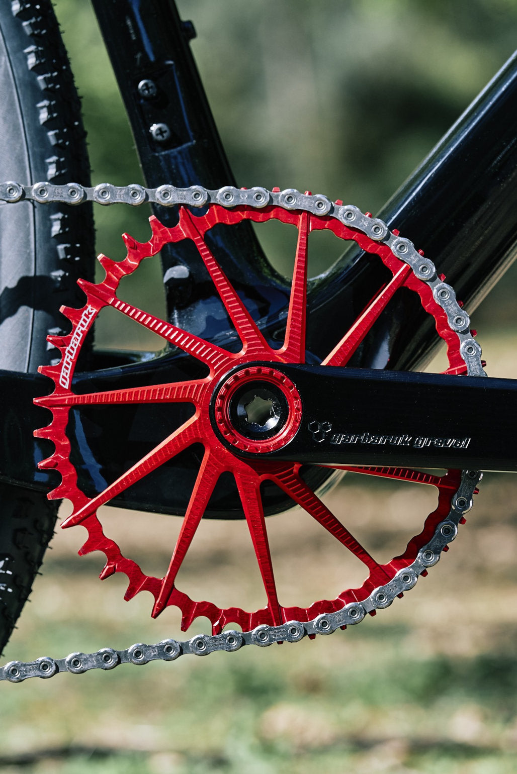 A red and black Garbaruk chainring and crank, fitted to a carbon Gothic Cycles gravel bike.