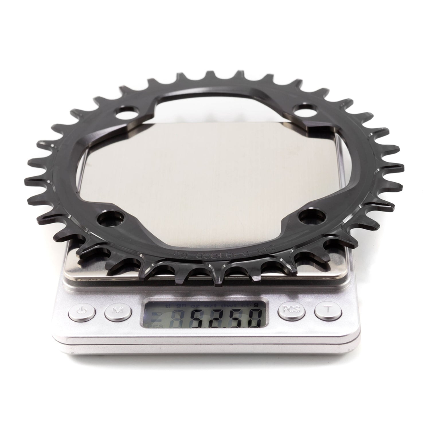 Garbaruk 104 BCD black chainring on a digital scale, which is displaying 52.5g