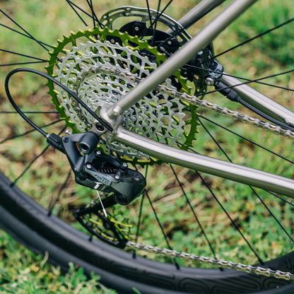Garbaruk 11-speed SRAM XD freehub cassette in green mounted on a Bossi bike, photographed outdoors against green lawn