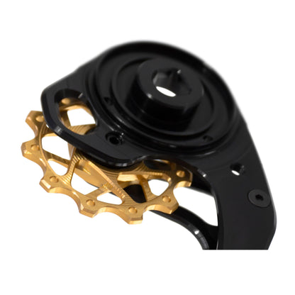 Close-up of Garbaruk pulley wheels and derailleur cage for SRAM Force AXS (black cage and gold pulley wheel), revealing detailed CNC machining and anodised finish