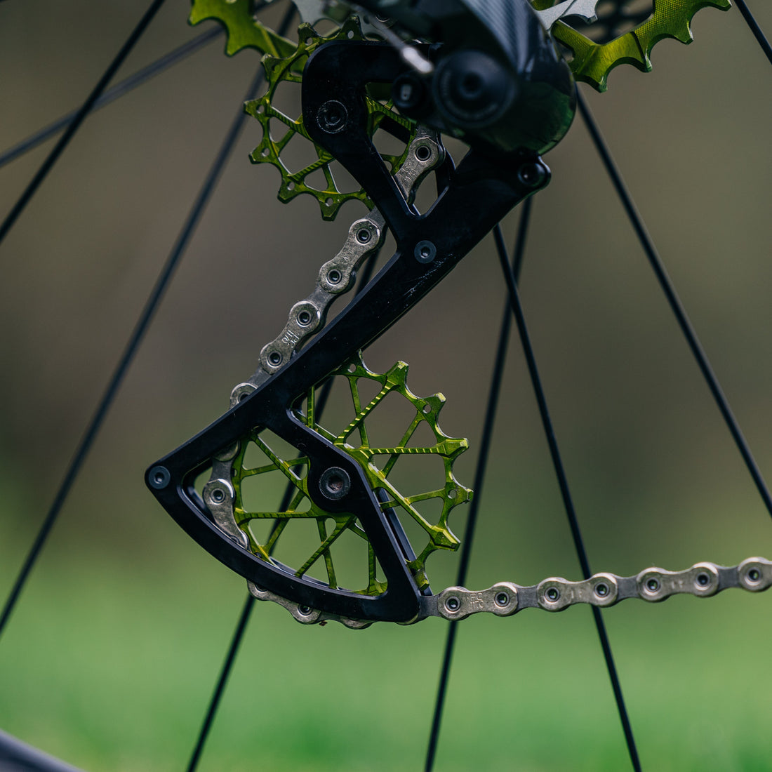 Close-up of Garbaruk green 12T + 16T derailleur pulleys fitted to a SRAM-equipped custom-built bike, shot outside to showcase colour-matched detailing and performance upgrades