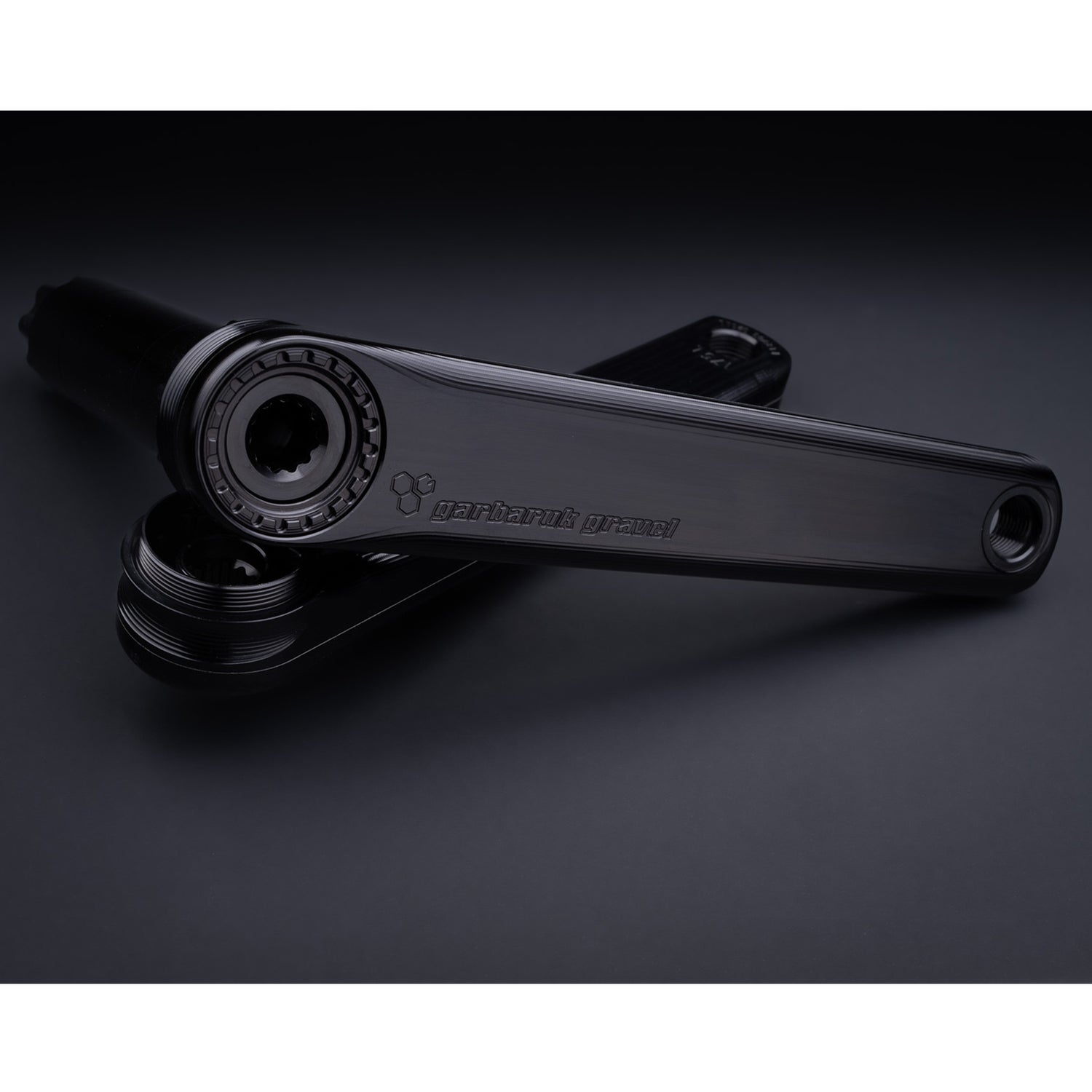 Detail of crank arm texture and laser-etched logo on Garbaruk road/gravel crankset in black