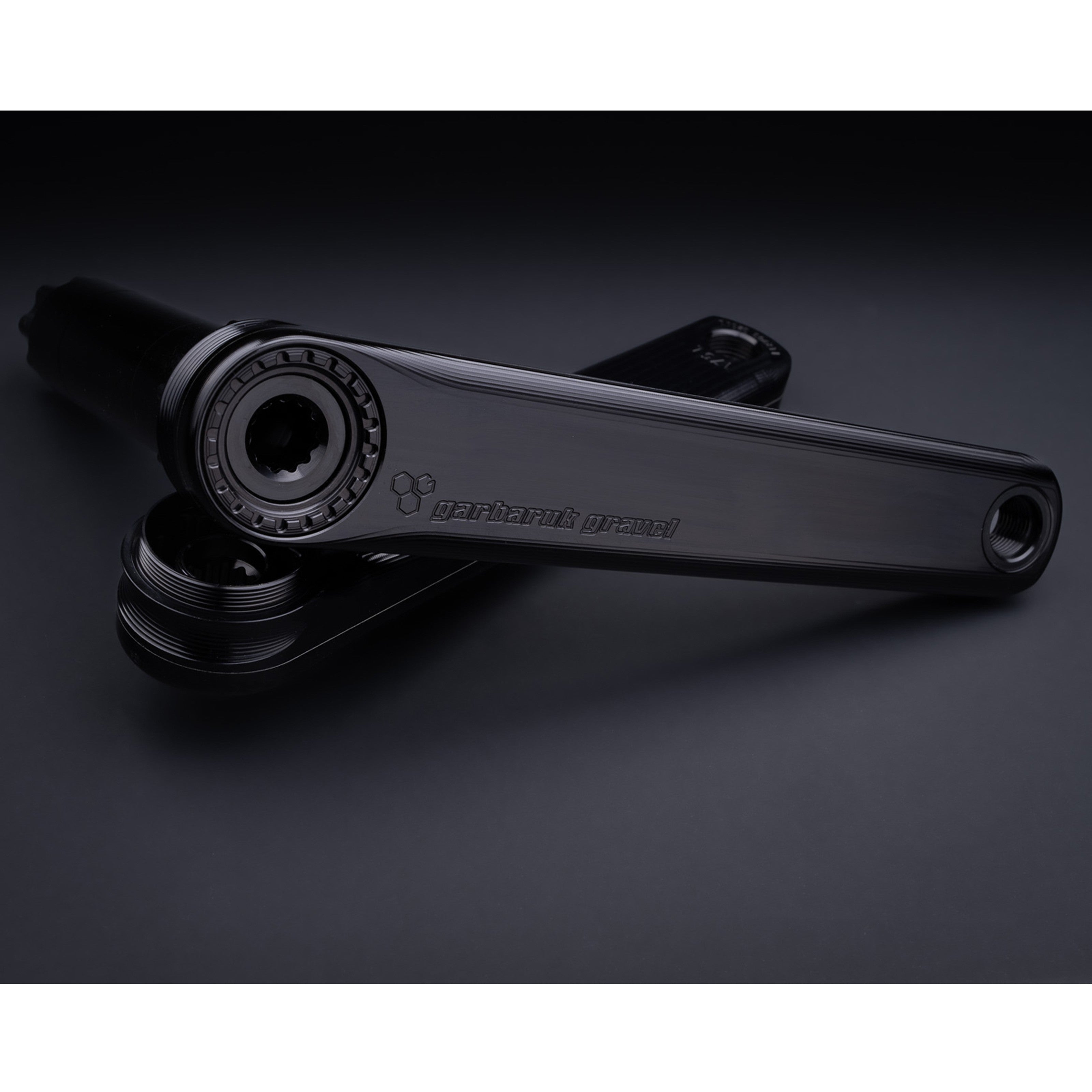 Detail of crank arm texture and laser-etched logo on Garbaruk road/gravel crankset in black