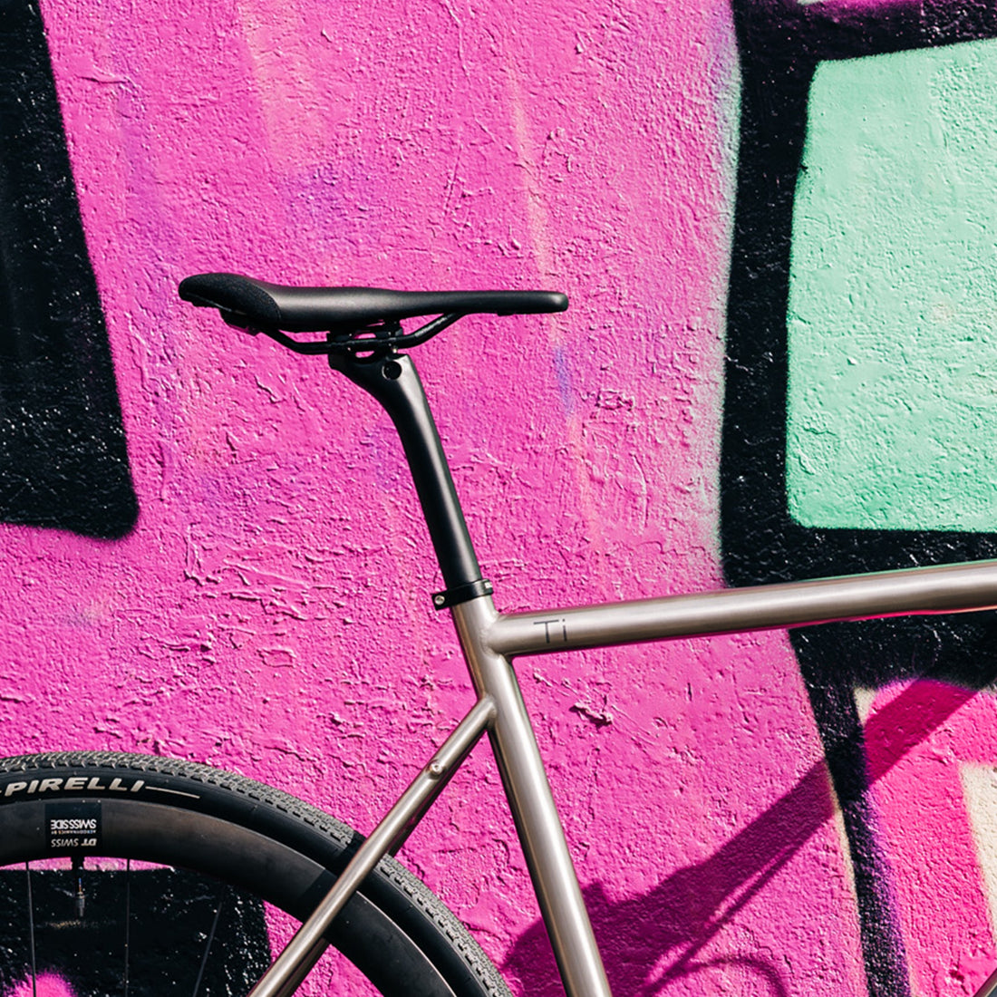 SQLab 614 Ergowave Active 2.1 saddle installed on a titanium Bossi bike, photographed outside against a colourful painted wall