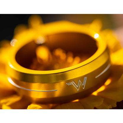 White Industries Seat Collar in metallic gold, sitting on a yellow flower